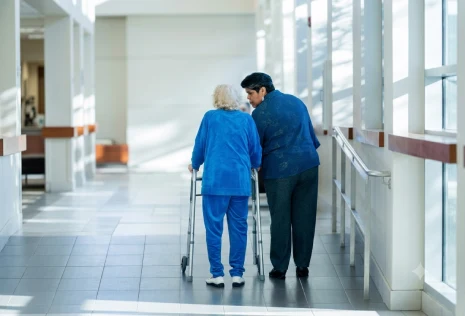 Healthcare professional assisting an elderly patient with personal care and mobility support