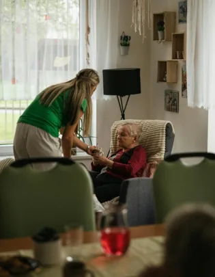 Caregiver assisting an elderly woman with daily activities at home