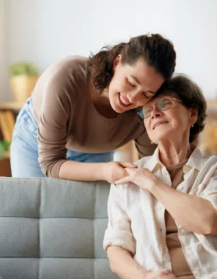 Caregiver providing compassionate support to an elderly woman at home